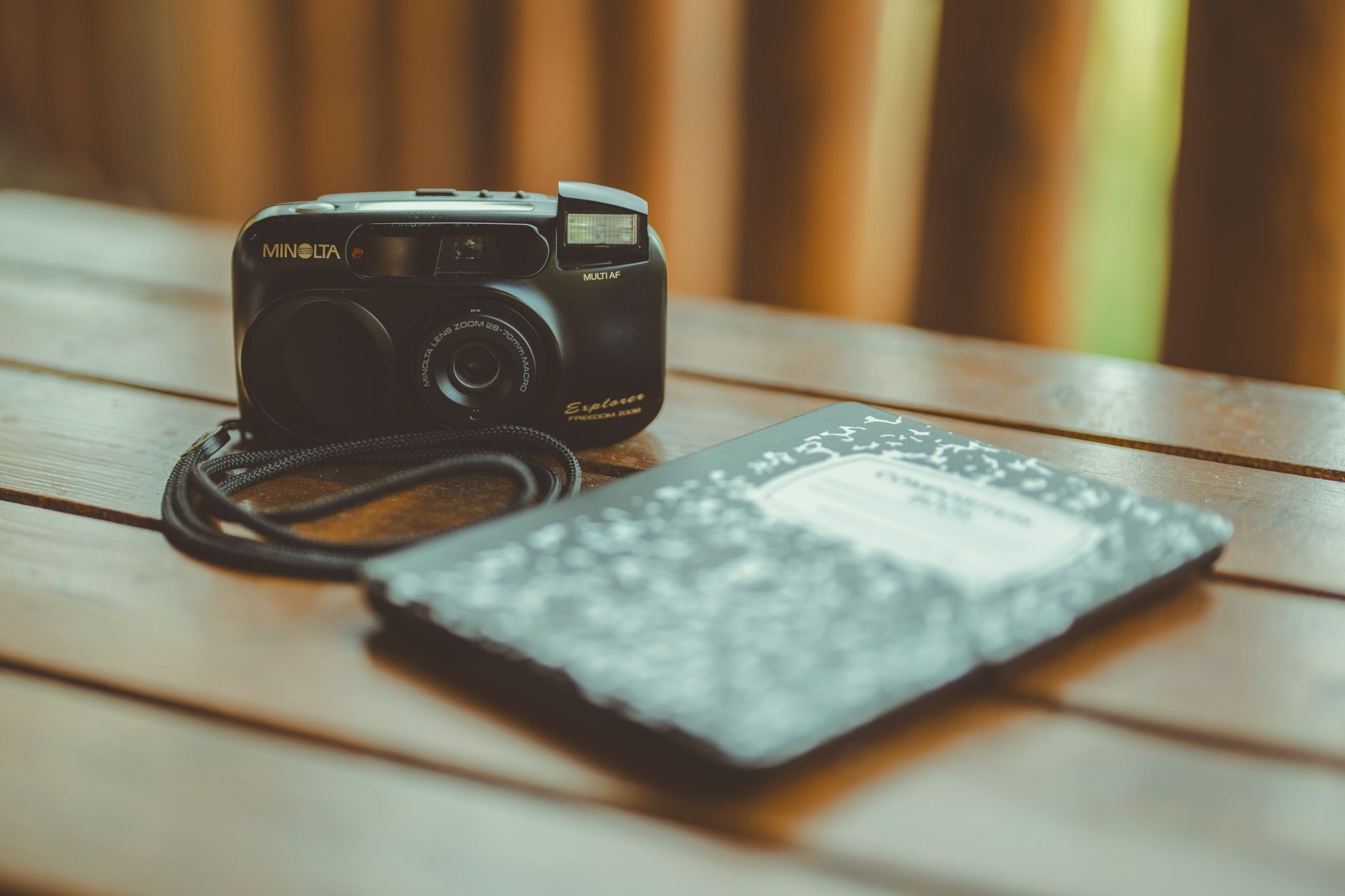 Travel journal notebook with camera on rustic table